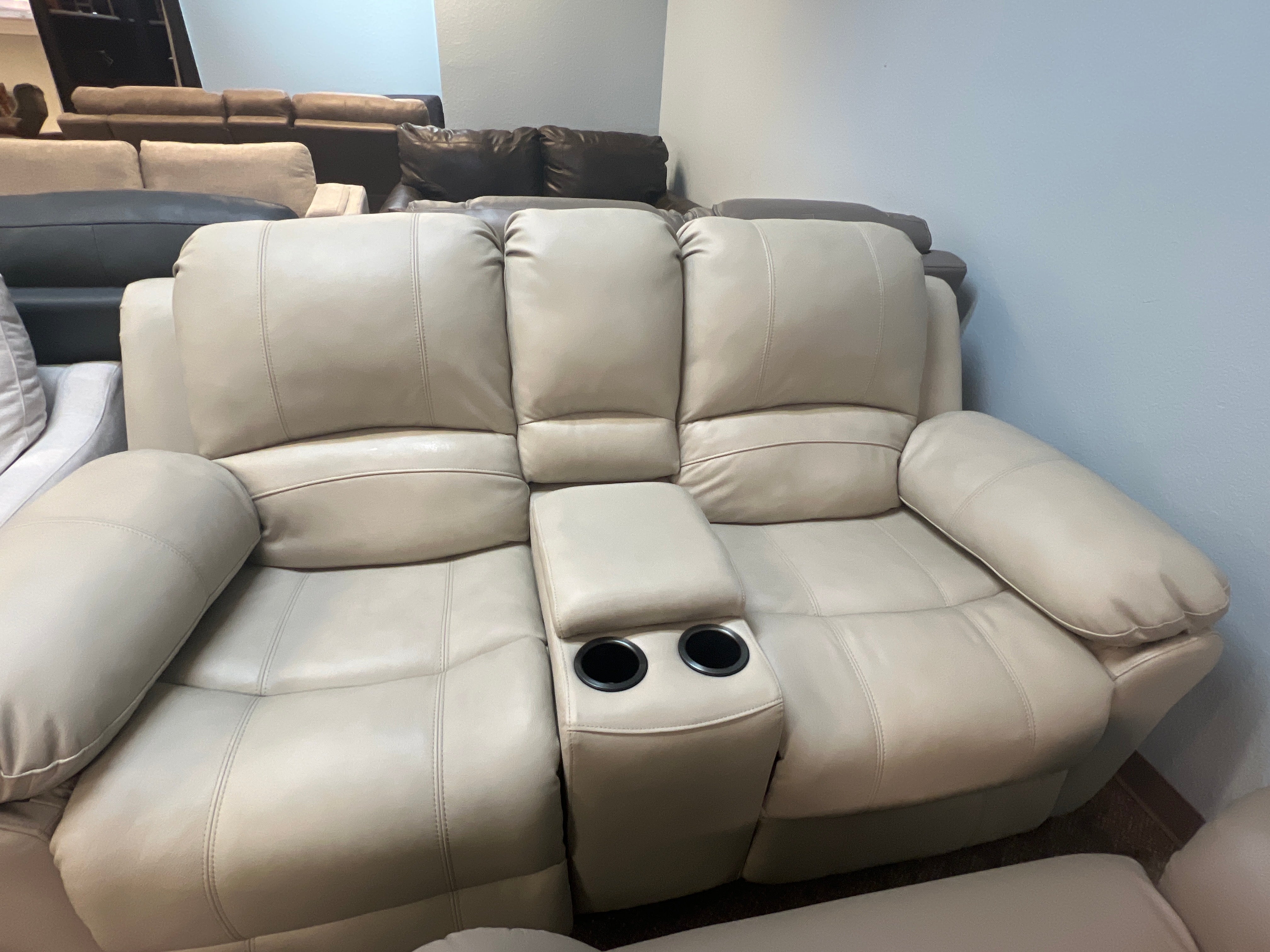 Cream Leather Reclining Sofa With Cup Holders and Center Storage
